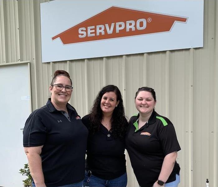 three women in SERVPRO uniform stand under a SERVPRO sign 