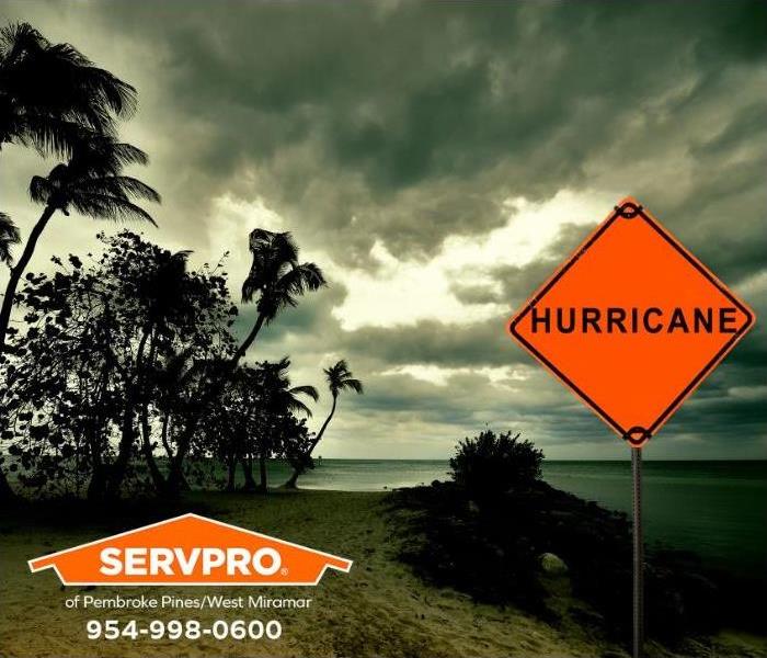 A sign reading hurricane sits next to a beach on a stormy day.