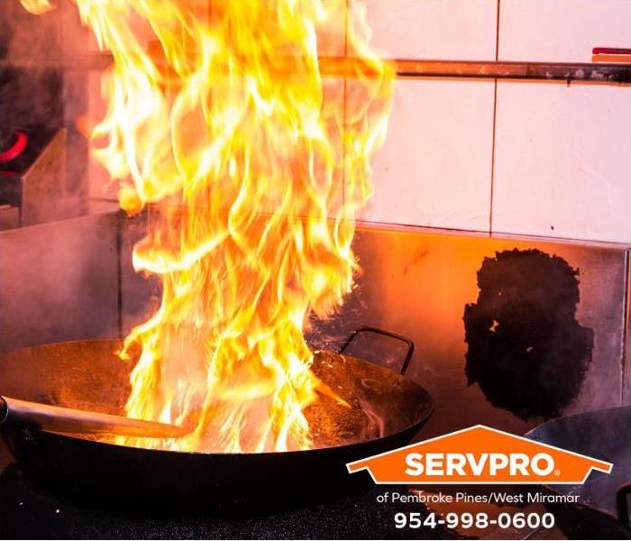 Flames shoot high into the air during stir-frying over a stove. 