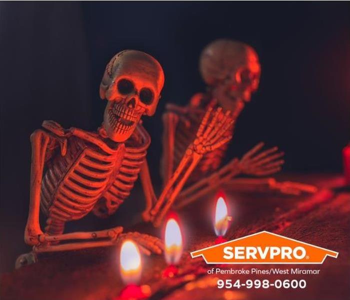 A Halloween display is decorated with skeletons and candles.